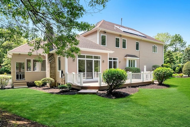 14 Sandpiper Hl, Sharon, MA 02067 - back of property with a wooden deck, a lawn, roof with shingles, and solar panels