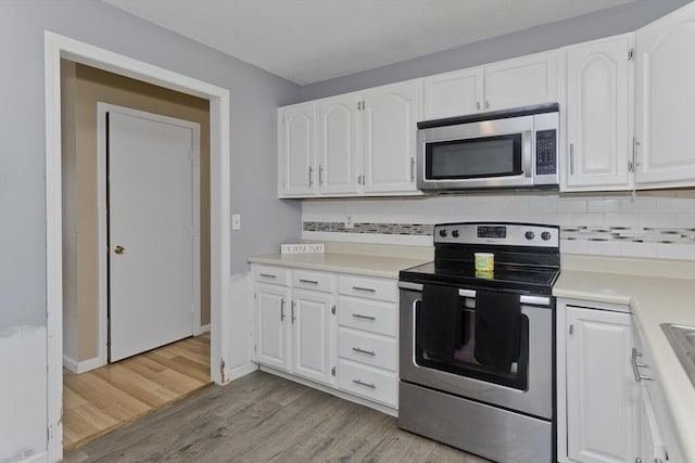 52 Marmon Ct, Springfield, MA 01129 - kitchen with stainless steel appliances, white cabinets, light countertops, and tasteful backsplash