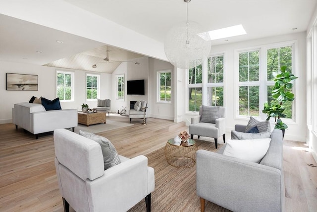 living room featuring light hardwood / wood-style flooring, vaulted ceiling, and plenty of natural light