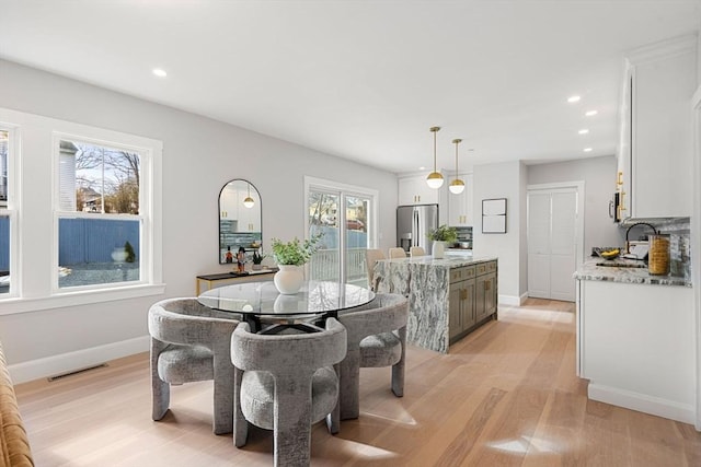 dining area featuring sink and light hardwood / wood-style floors