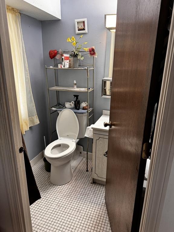 685 Oak St Unit 20-8, Brockton, MA 02301 - half bathroom with baseboards, toilet, tile patterned flooring, and vanity