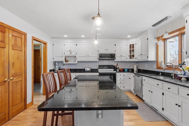 76 Woobly Rd, Bolton, MA 01740 - kitchen featuring stainless steel appliances, a sink, light wood finished floors, a center island, and white cabinets