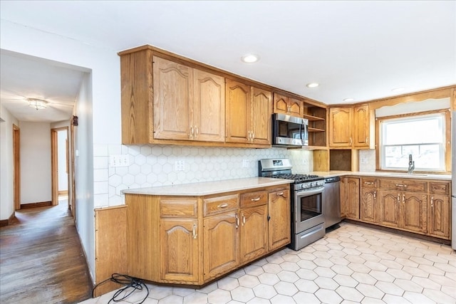 kitchen with light hardwood / wood-style floors, stainless steel appliances, sink, and decorative backsplash