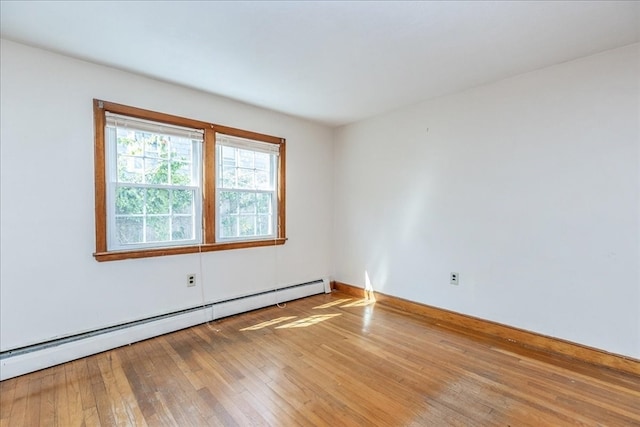 empty room with wood-type flooring and baseboard heating