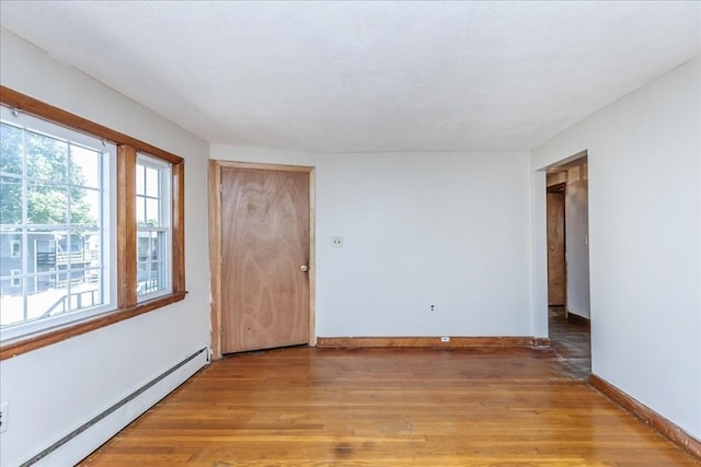 spare room with light wood-type flooring and a baseboard radiator