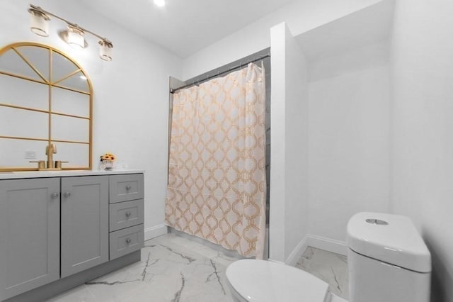 bathroom featuring baseboards, toilet, marble finish floor, and vanity