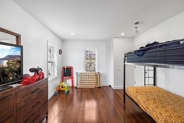 bedroom with visible vents, multiple windows, baseboards, and hardwood / wood-style floors