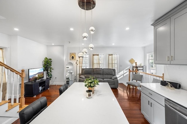 dining space with arched walkways, stairway, recessed lighting, and dark wood-style floors