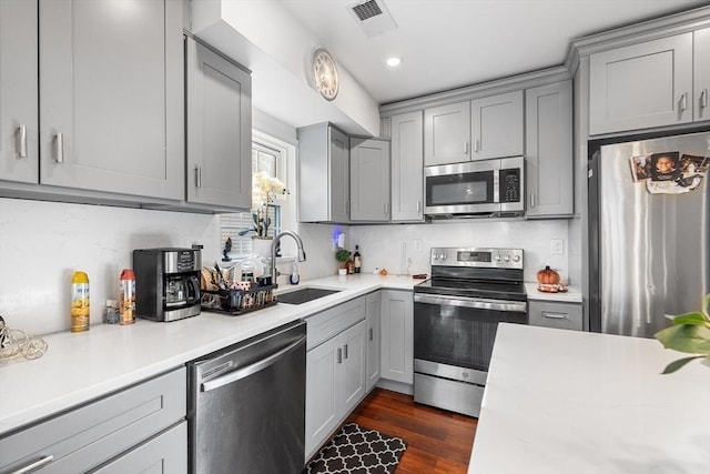 kitchen featuring a sink, stainless steel appliances, gray cabinets, and light countertops