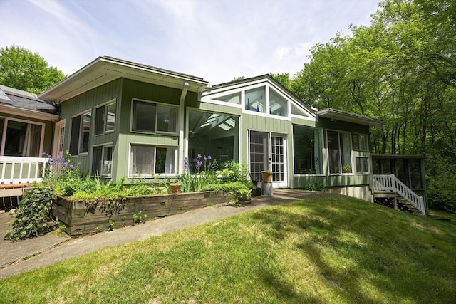 5 Deerfield Rd, Medway, MA 02053 - rear view of house with a sunroom, board and batten siding, and a lawn
