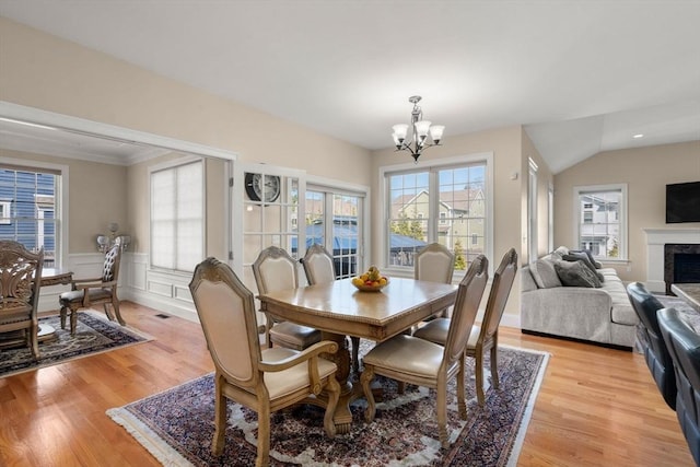 50 Sterling Rd, Needham, MA 02492 - dining space featuring a chandelier, light wood-type flooring, a fireplace, wainscoting, and ornamental molding