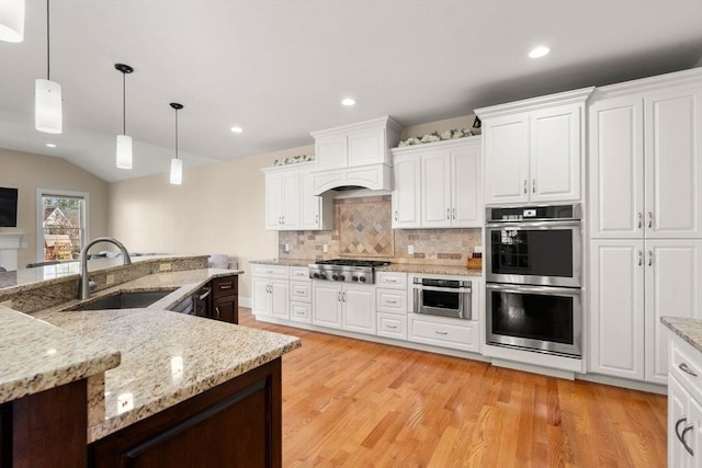50 Sterling Rd, Needham, MA 02492 - kitchen featuring stainless steel appliances, a sink, light wood-type flooring, white cabinetry, and recessed lighting