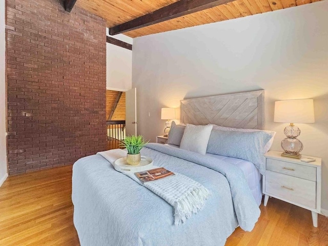 bedroom with wood ceiling, wood finished floors, beamed ceiling, and brick wall