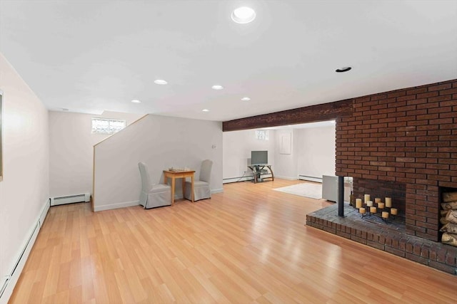 unfurnished living room featuring baseboard heating, a baseboard radiator, a fireplace, and wood finished floors