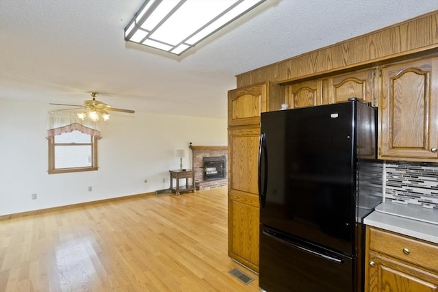 kitchen with a ceiling fan, visible vents, tasteful backsplash, freestanding refrigerator, and light wood-style floors
