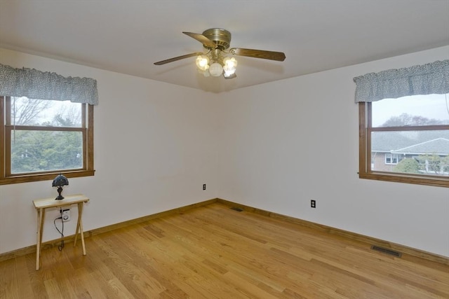 unfurnished room featuring visible vents, a ceiling fan, light wood finished floors, and baseboards