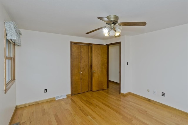 unfurnished bedroom with visible vents, baseboards, a closet, and light wood-type flooring
