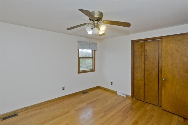 unfurnished bedroom featuring visible vents, baseboards, a closet, and light wood-type flooring