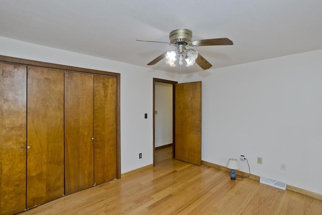 unfurnished bedroom featuring a ceiling fan, visible vents, light wood-type flooring, baseboards, and a closet