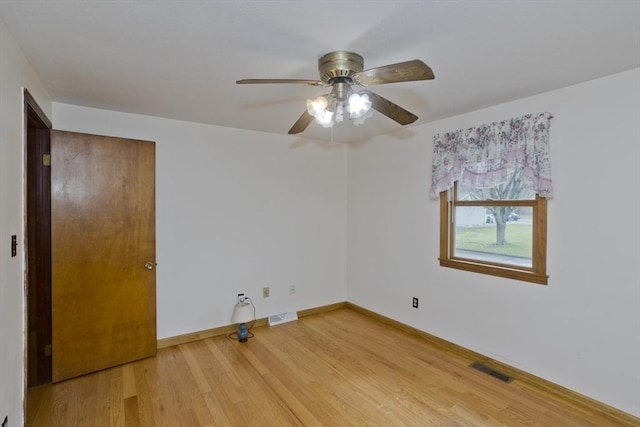 unfurnished room featuring baseboards, a ceiling fan, wood finished floors, and visible vents