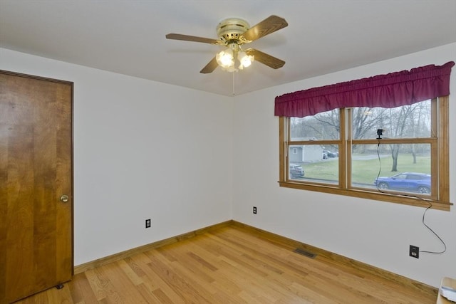empty room featuring visible vents, baseboards, ceiling fan, and light wood-type flooring