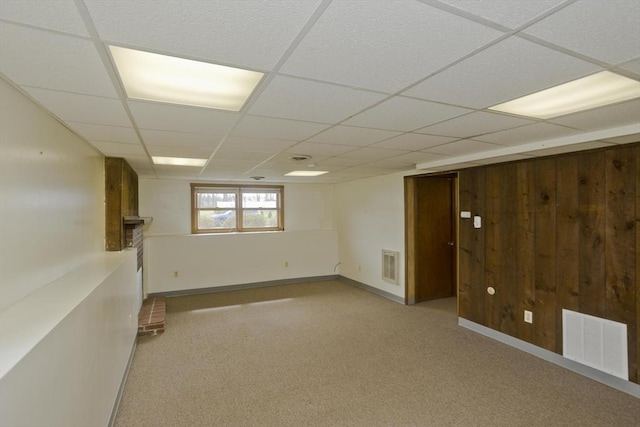basement with visible vents, carpet, and a paneled ceiling
