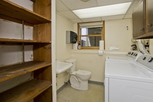 washroom featuring baseboards, light floors, and washer and dryer
