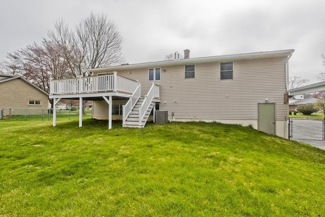 back of house with stairway, a lawn, fence, and a wooden deck