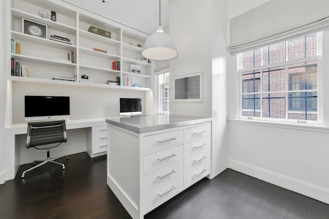 office space featuring dark hardwood / wood-style flooring and built in desk