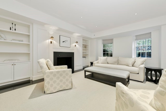 living room with built in features and light wood-type flooring