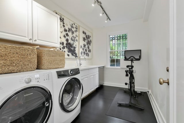 clothes washing area featuring sink, cabinets, washer and clothes dryer, and rail lighting