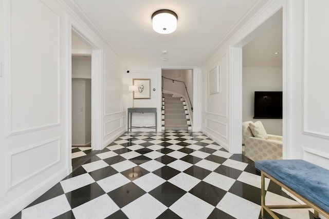 hallway featuring dark tile patterned floors and crown molding