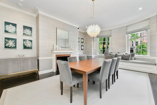 dining space featuring hardwood / wood-style flooring, crown molding, and a chandelier