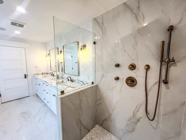 bathroom with visible vents, a marble finish shower, double vanity, a sink, and marble finish floor