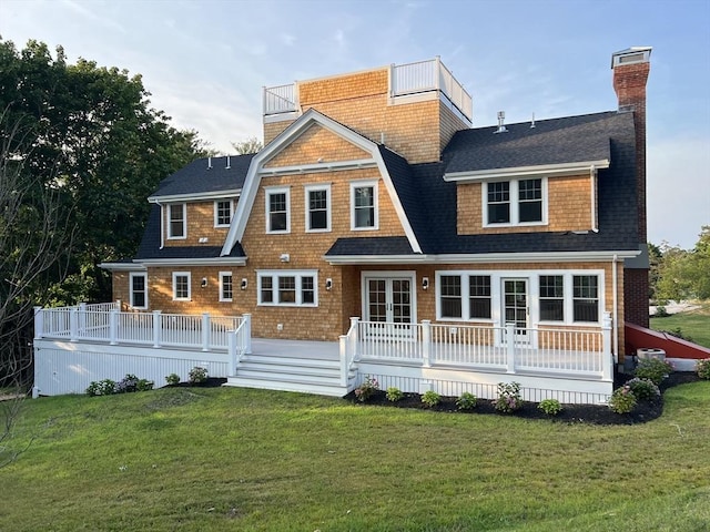 rear view of house featuring a gambrel roof, french doors, a yard, roof with shingles, and a chimney