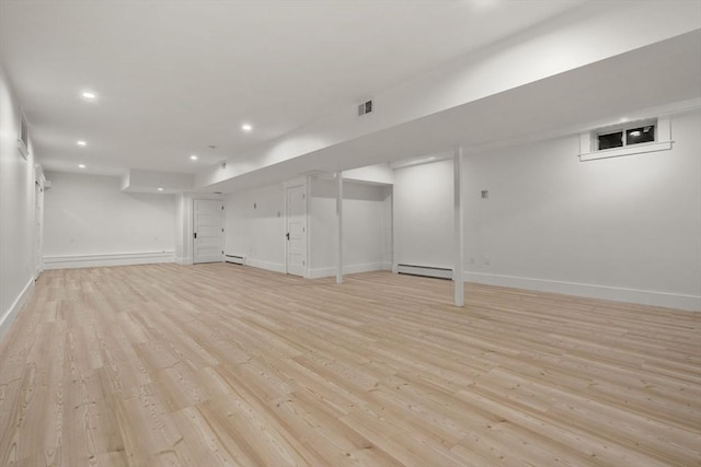 finished below grade area featuring recessed lighting, visible vents, light wood finished floors, and baseboards