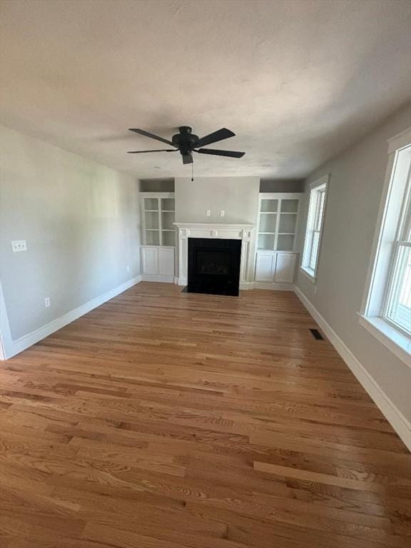 77 Lake Shore Dr, Weymouth, MA 02189 - unfurnished living room featuring built in features, ceiling fan, baseboards, and wood finished floors