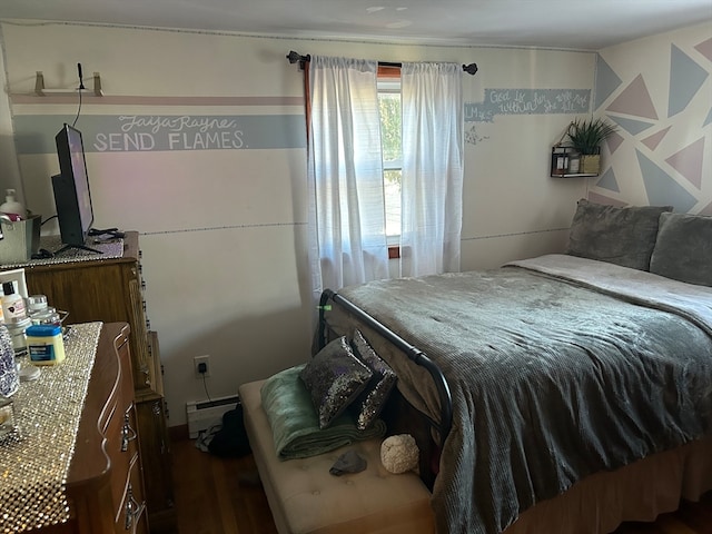 bedroom with baseboard heating and dark hardwood / wood-style floors