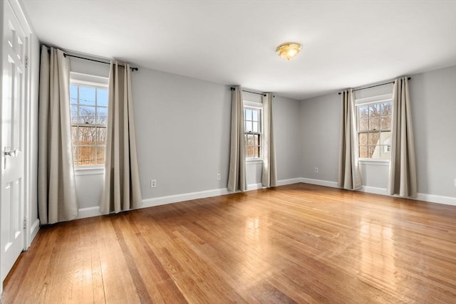 unfurnished room with baseboards and light wood-style flooring