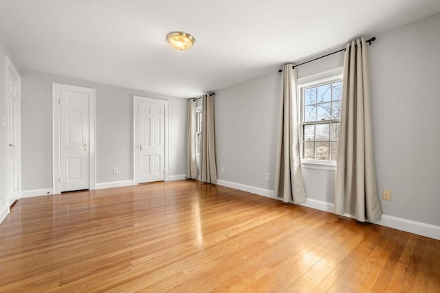 unfurnished bedroom with baseboards and light wood-type flooring