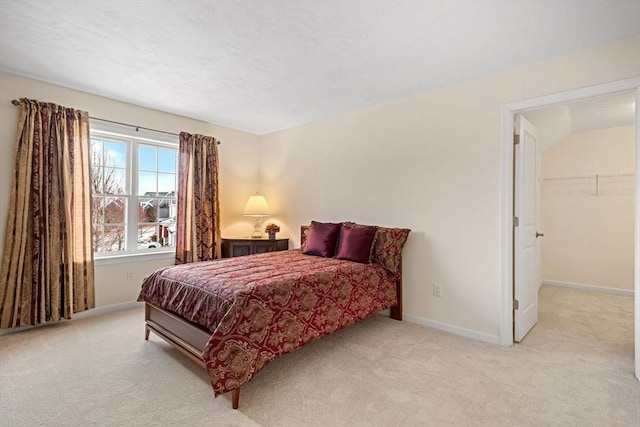 carpeted bedroom with a walk in closet and a closet