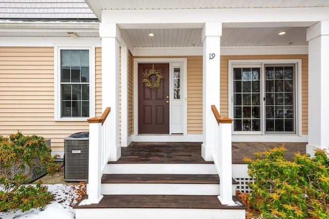 doorway to property with cooling unit and a porch