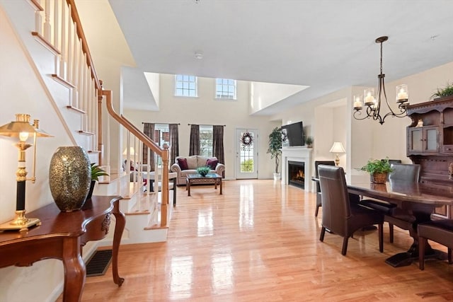 interior space featuring a chandelier, light hardwood / wood-style flooring, and a high ceiling