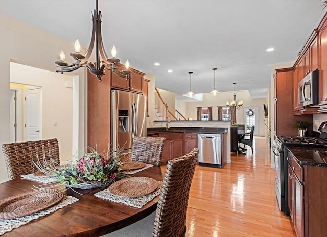 dining space with sink, a chandelier, and light hardwood / wood-style floors