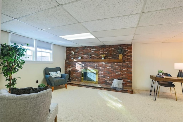 sitting room with carpet floors, a paneled ceiling, and a fireplace