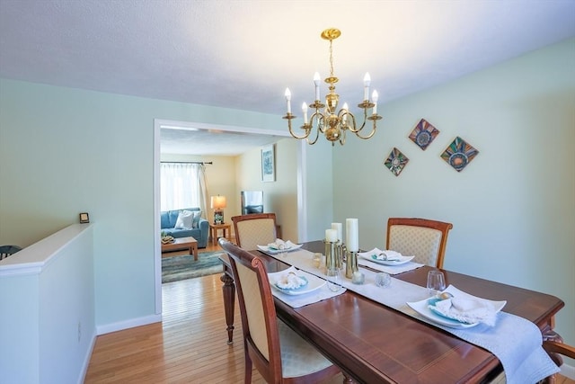 dining room featuring light hardwood / wood-style flooring and an inviting chandelier