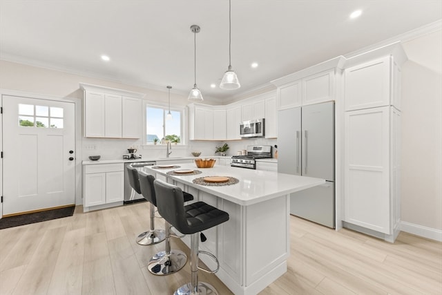 kitchen with white cabinets, appliances with stainless steel finishes, and a healthy amount of sunlight