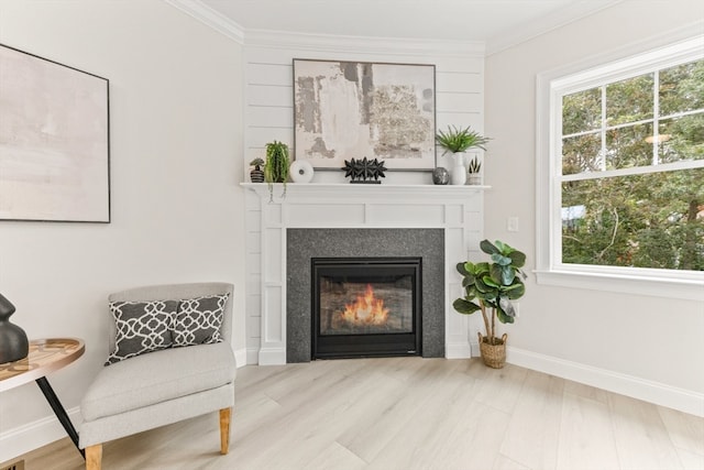 sitting room featuring ornamental molding and light wood-type flooring