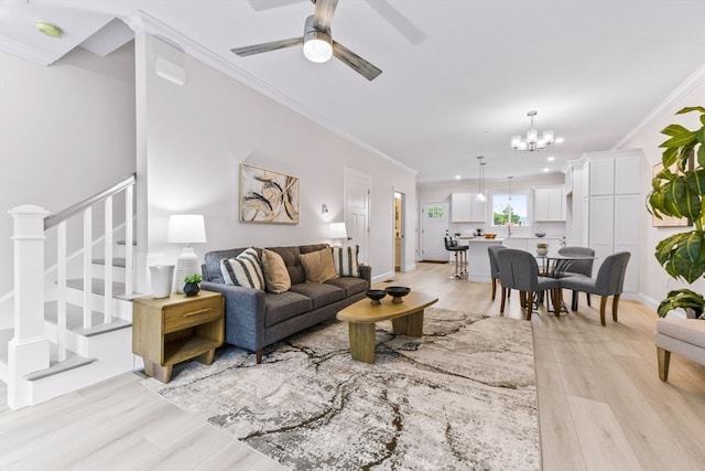 living room featuring ceiling fan with notable chandelier, crown molding, and light hardwood / wood-style flooring