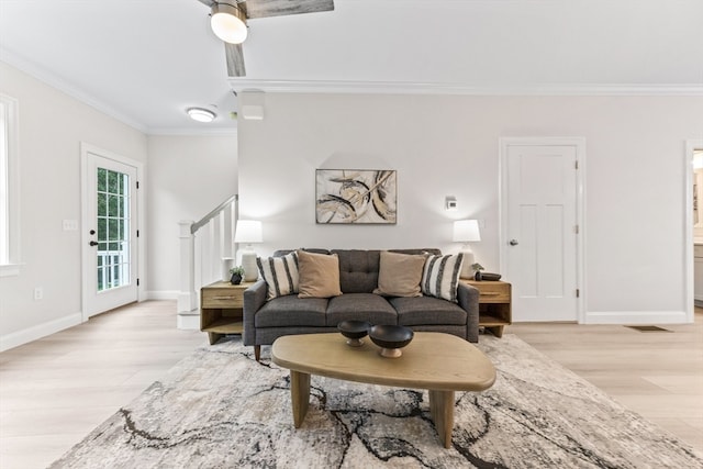 living room featuring light hardwood / wood-style flooring, ceiling fan, and crown molding